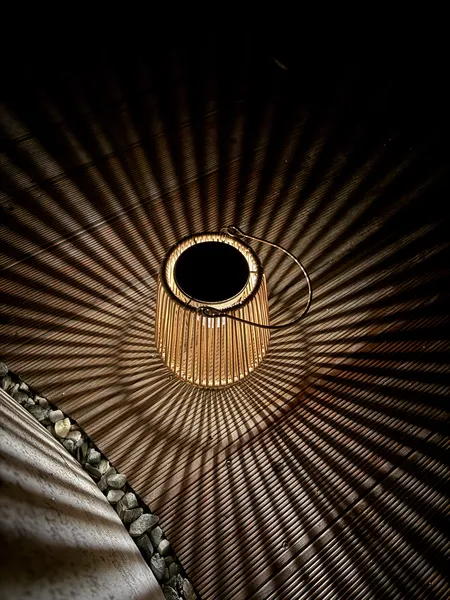 Bamboo solar lantern casting radial shadow pattern