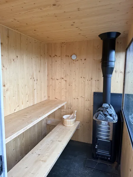 Bright sauna interior with Harvia stove and wooden benches