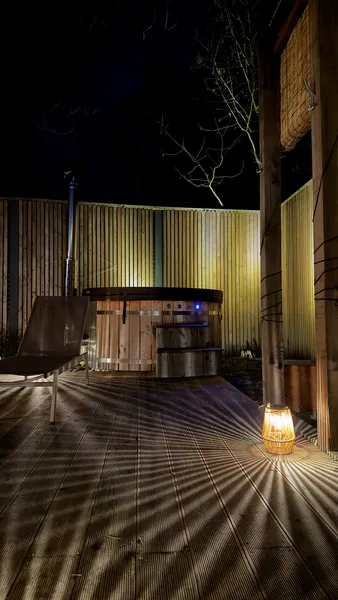 Hot tub at night illuminated by solar lantern on the deck